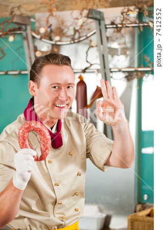 Butcher with Fresh Smoked Sausage 7412552