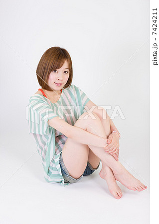 膝を抱えて座る女性の写真素材