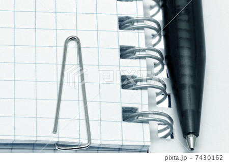 Paper clip  on notebook pages with pen. Isolated over white. 7430162