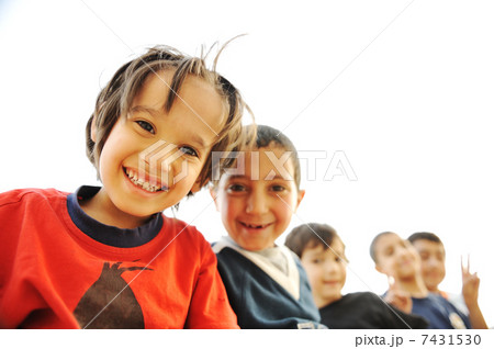 Below view of happy children embracing each other and smiling at camera Below view of happy children embracing each other and smiling at camera 7431530