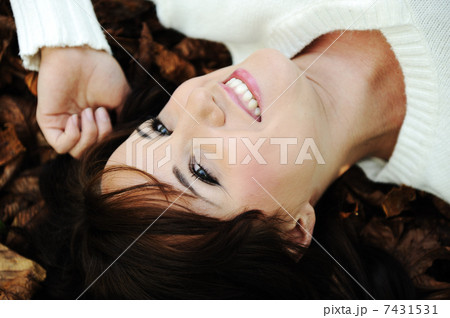 Close-up portrait of an beautiful autumn woman laying on ground Close-up portrait of an beautiful autumn woman laying on ground 7431531
