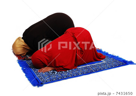 Young muslim female in traditional clothes praying with little girl 7431650