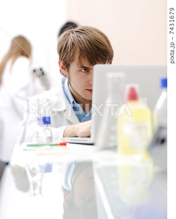 Young medical scientist working in modern lab, research with tubes and notebook 7431679