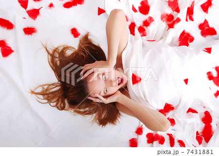 Beautiful girl laying on bed with white sheets screaming 7431881