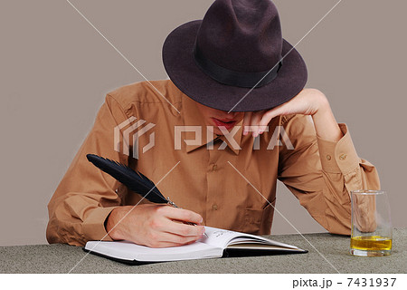 A poet writting on desk with the glass beside 7431937