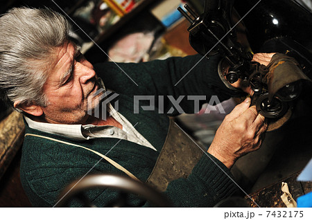 Senior man working with old machine in his own workshop Senior man working with old machine in his own workshop 7432175