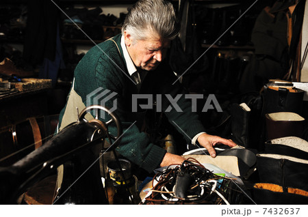 Senior man working with old machine in his own workshop 7432637