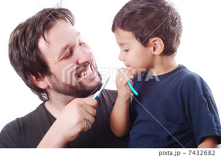 Father teaching his son how to clean the teeth Father teaching his son how to clean the teeth 7432682