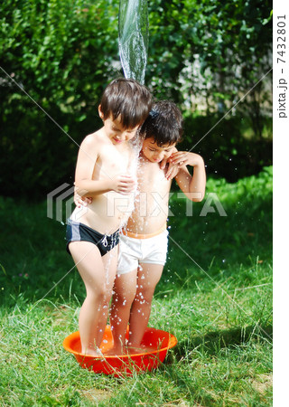 Two kids summer playing with water outdoor 7432801