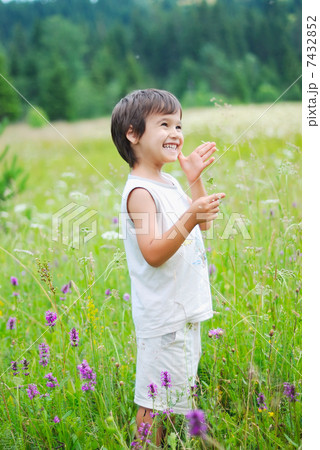 Cute little boy on green grass in nature 7432852