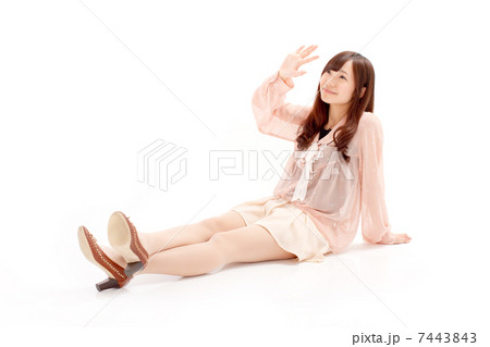 爽やかな夏物衣装に身を包み腰を下ろす可愛い女の子 7443843