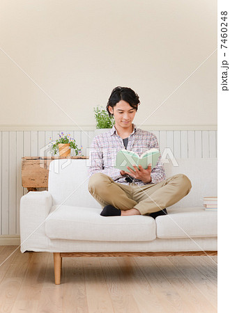 あぐらをかいて読書する男性の写真素材