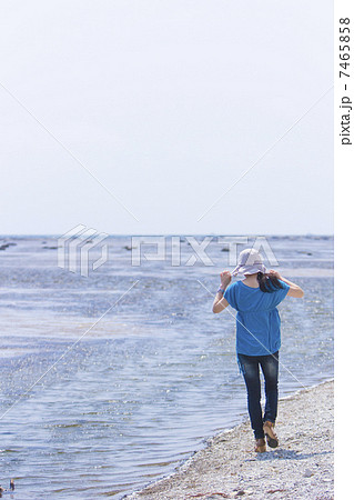 波打ち際を歩く女性 7465858