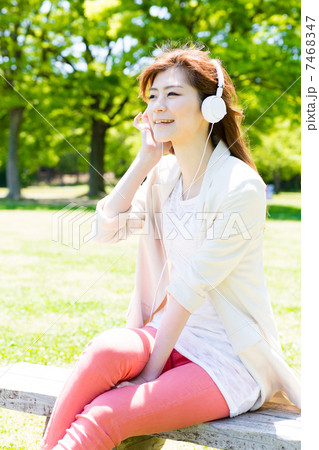公園で音楽を聴く女性 7468347