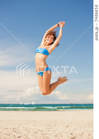 happy jumping woman on the beach 7486658