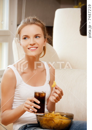 smiling teenage girl with chips and coke smiling teenage girl with chips and coke 7487219