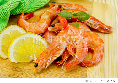 Shrimps on board with lemon slices Shrimps on board with lemon slices 7490145