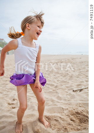 Young girl playing on beach 7491119