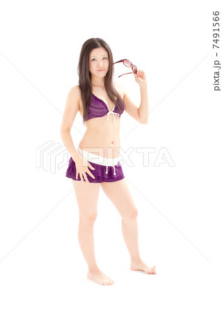 サングラスを片手に格好良くポーズをとる水着の女性 7491566