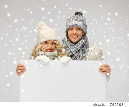 couple in a winter clothes holding blank board couple in a winter clothes holding blank board 7495084