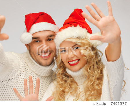 family couple in sweaters and santas hats 7495577