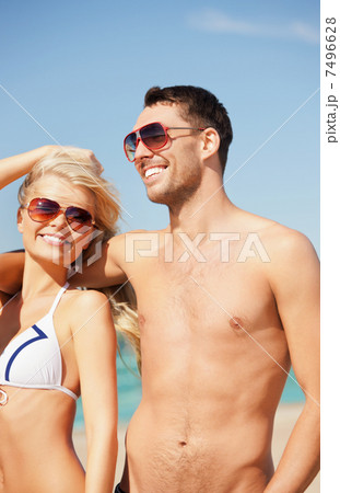 happy couple in sunglasses on the beach 7496628
