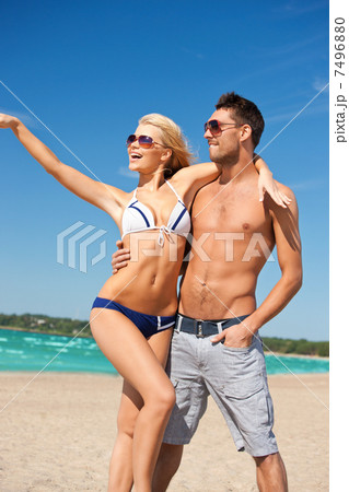 happy couple in sunglasses on the beach happy couple in sunglasses on the beach 7496880