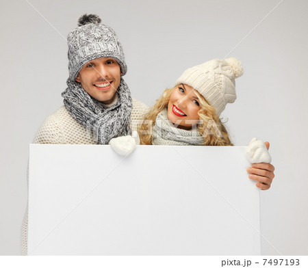 couple in a winter clothes holding blank board 7497193