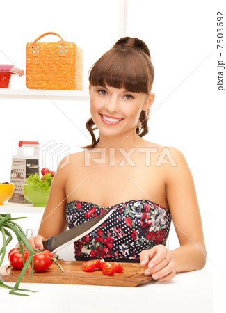 beautiful woman in the kitchen cutting vegetables 7503692