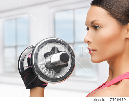 woman with heavy steel dumbbell 7506450