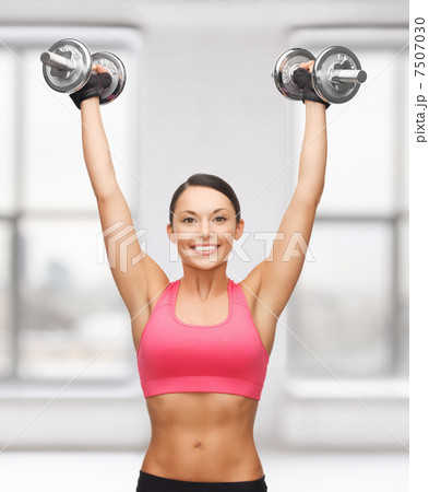 woman with heavy steel dumbbells woman with heavy steel dumbbells 7507030