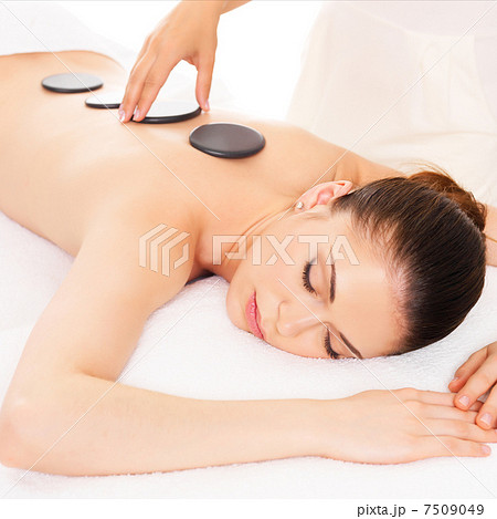 Woman having hot stone massage in spa salon. 7509049
