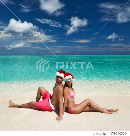 Couple in santa's hat on a beach at Maldives Couple in santa's hat on a beach at Maldives 7509299