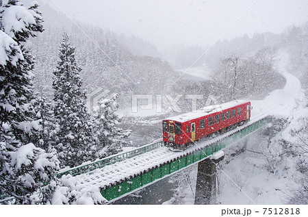 雪の中鉄橋を渡る列車 7512818