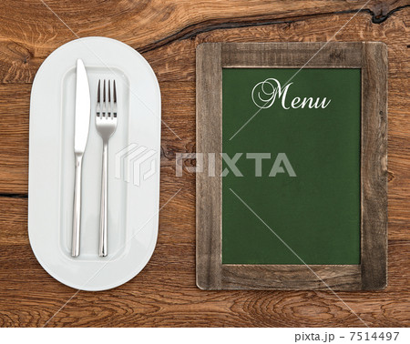 chalkboard with white plate, knife and fork 7514497