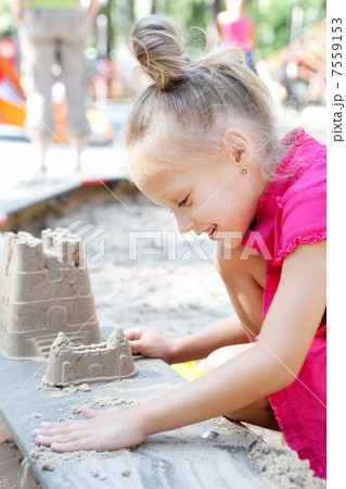 Little happy girl building a sand castle in the sandbox Little happy girl building a sand castle in the sandbox 7559153