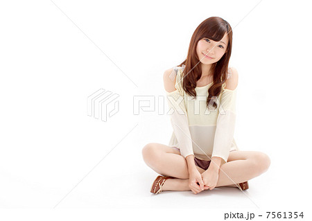 ラブリーな夏服を着て可愛らしくあぐらをするキュートな女の子の写真素材