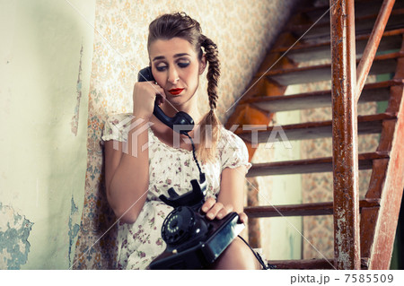 Woman sitting on the stairs and crying on the phone 7585509