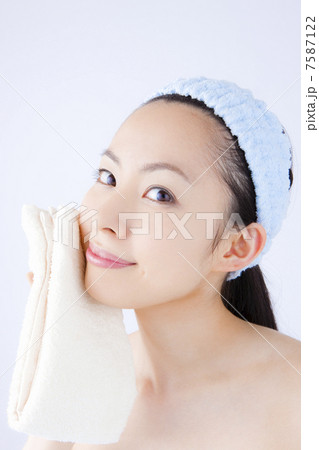 顔をタオルで押さえる女性 7587122
