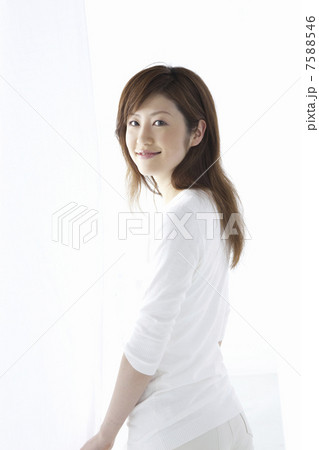 カーテン越しに微笑む女性 7588546