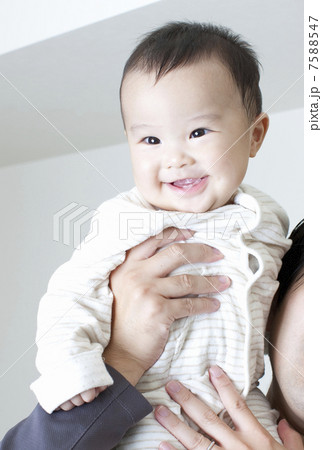 お父さんに抱き上げられる赤ちゃん お父さんに抱き上げられる赤ちゃん 7588547