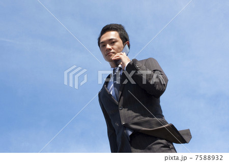 携帯電話で話すビジネスマン 7588932