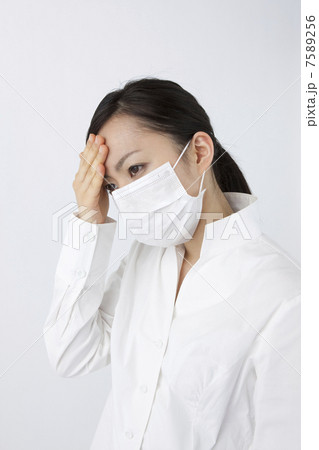 頭を押さえる女性 7589256