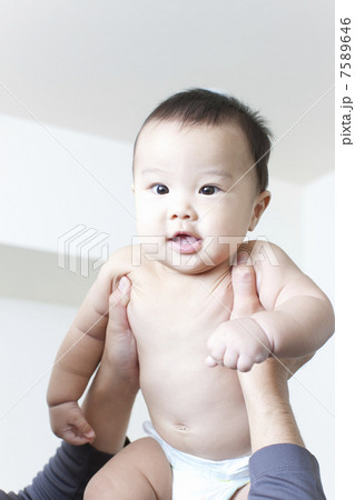 お父さんに抱き上げられる赤ちゃん お父さんに抱き上げられる赤ちゃん 7589646
