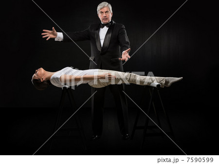 Portrait of professional hypnotist on black background working w 7590599