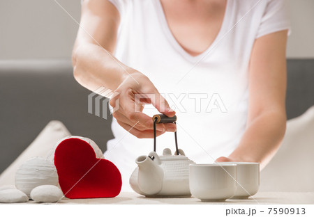 Detail shot of female arm holding tea pot and welcoming to joing 7590913