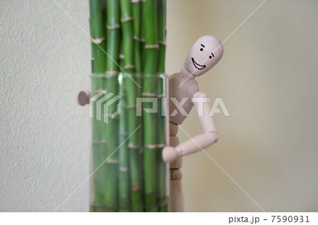 Wooden man standing at home and looking out of the tree. People 7590931