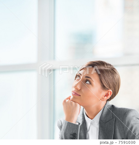 A creative young business woman looking away with hand on her ch 7591030