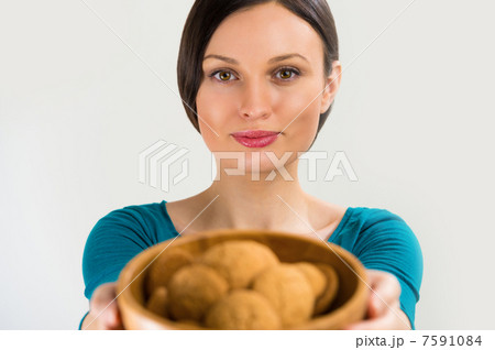 Beautiful woman holding hot fresh smelling oat cookies and smili Beautiful woman holding hot fresh smelling oat cookies and smili 7591084