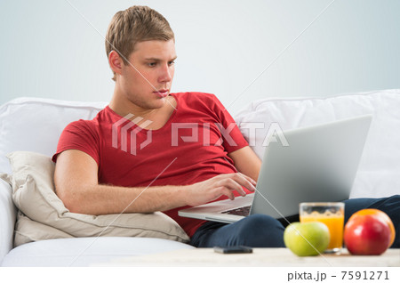 Portrait of a young guy using laptop at home 7591271